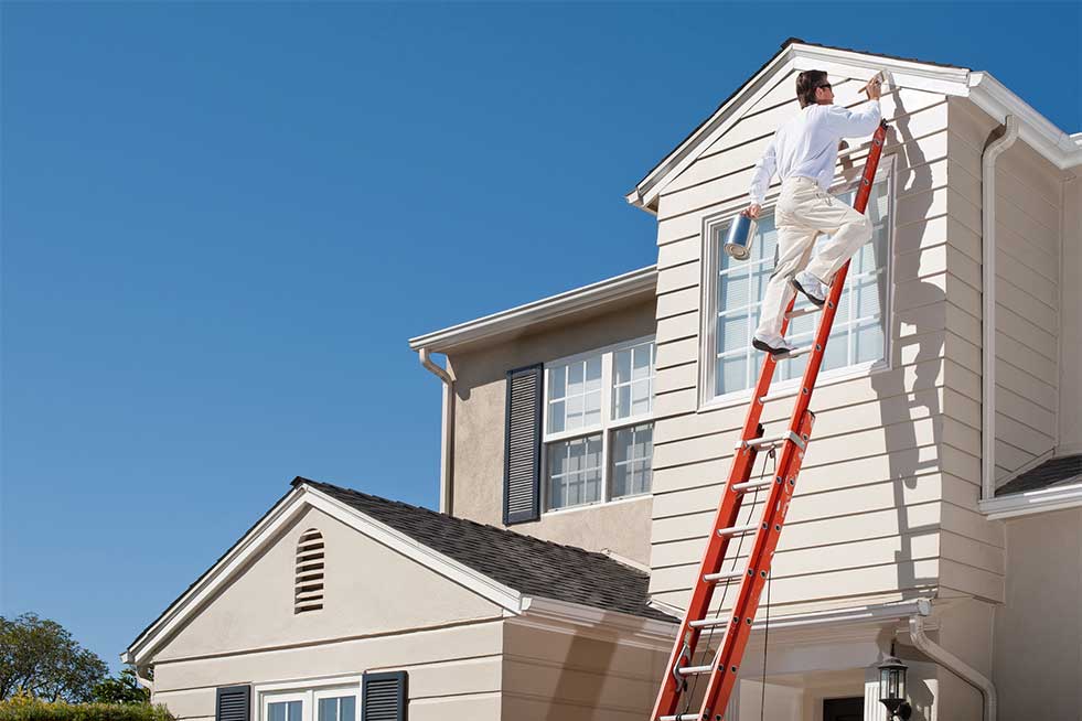 man painting the exterior of a house